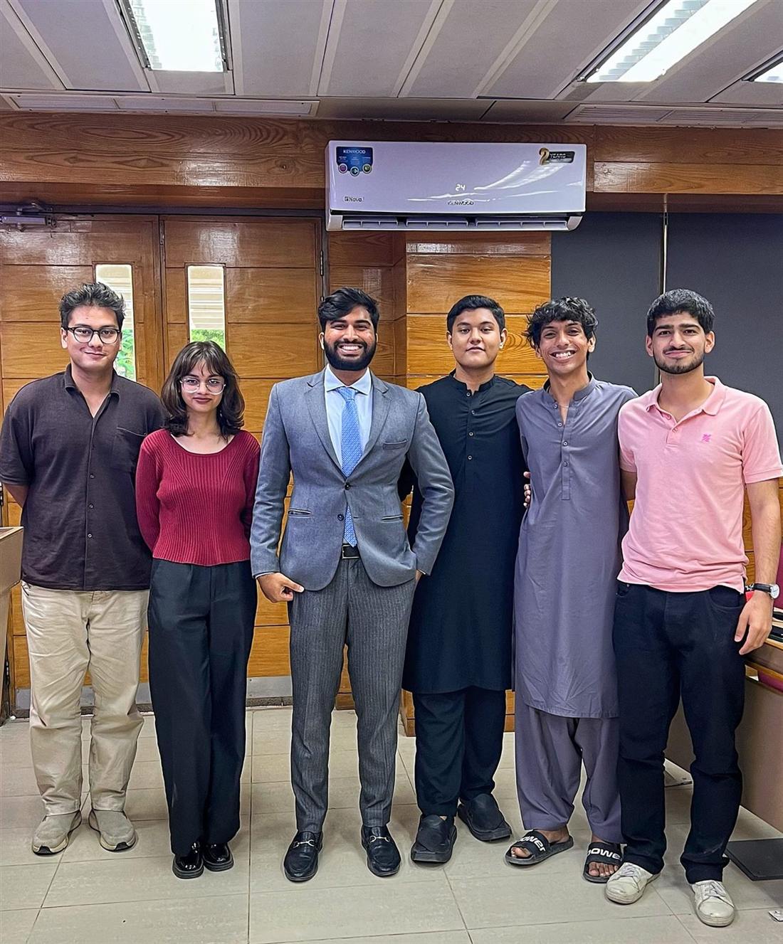 MUN Society Pakistan delegates in a team debrief after a committee session.