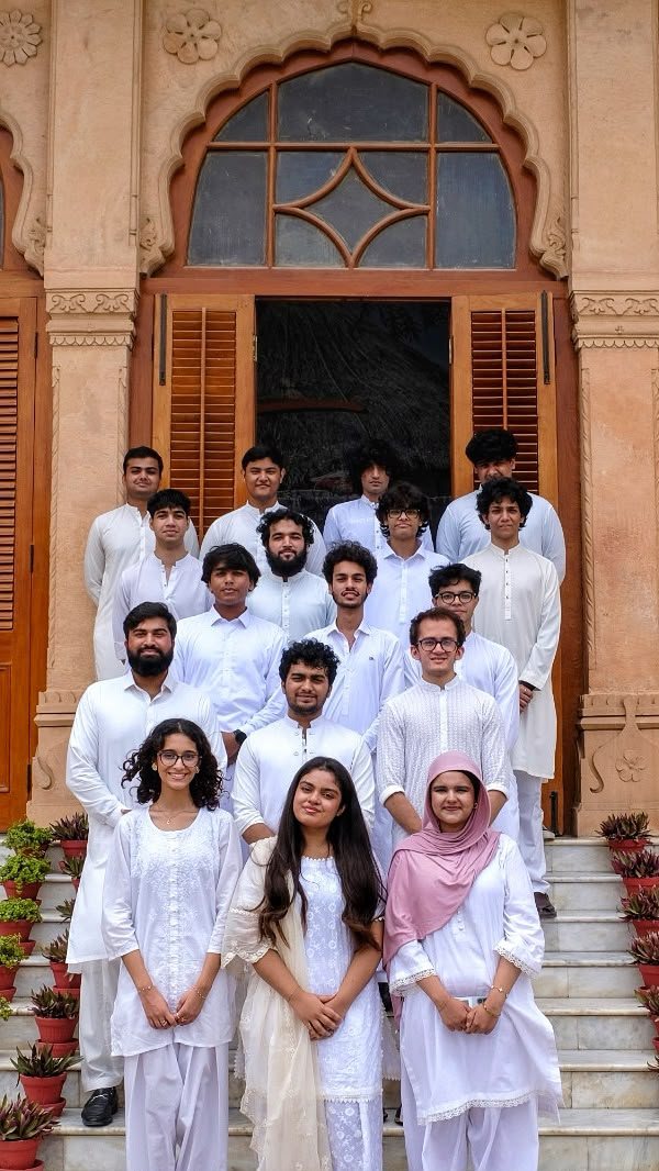 The MUN Society Pakistan team in white on the steps of Mohatta Palace, Karachi.